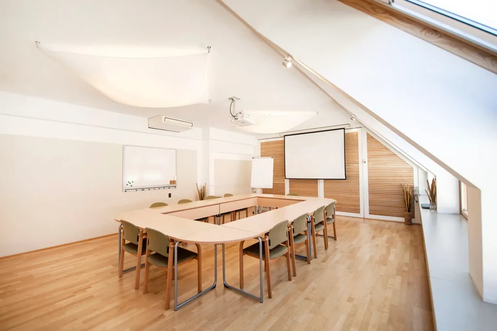 Seminarraum Berg7 Wien in U-Form-Aufstellung mit Beamer und Whiteboard